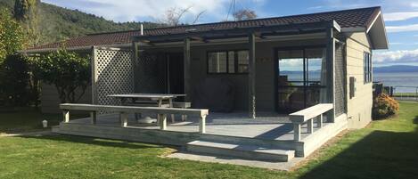 A modern house with a patio, a table, and a bench.