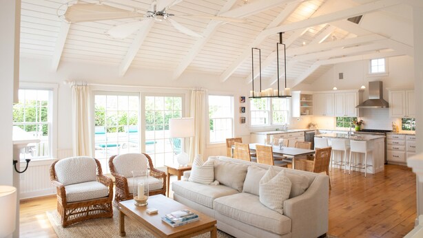 A spacious living room with a high ceiling, white furniture, and large windows. - Upscale Beach House Brant Point (Nantucket)