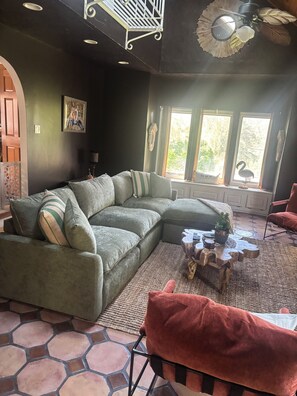 Een gezellige woonkamer met een modulaire bank, een salontafel en een rode fauteuil.