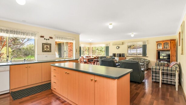 A spacious living area with a kitchen, dining area, and a cozy seating area with a television.