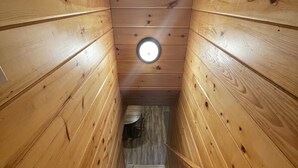 Una escalera de madera con un tragaluz circular en la parte superior.