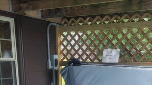 Un jacuzzi con cubierta de madera y escalones que dan acceso a él.