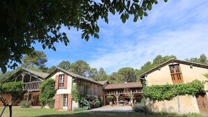 A rustic house with a patio, wooden deck, and a stone wall. - Mansion - RIMBEZ ET BAUDIETS (Rimbez-et-Baudiets)
