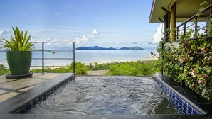 A hot tub with a view of the beach and mountains.