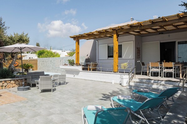 A patio with outdoor furniture, a pergola, and a view of the surrounding area.