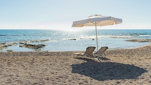 A beach with two sun loungers and a beach umbrella. - Villa Perla with Sea View (rhodes)