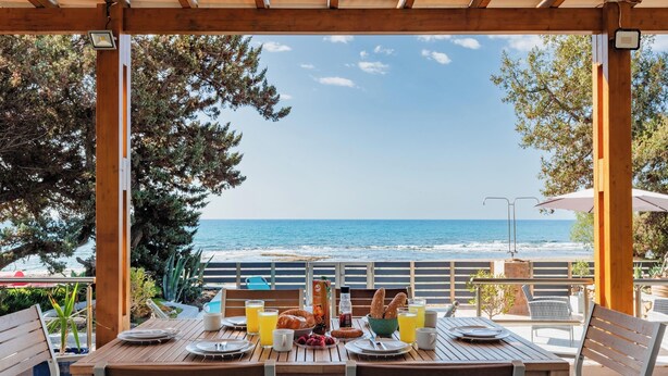 A wooden table set for breakfast with a view of the ocean. - Villa Perla with Sea View (rhodes)