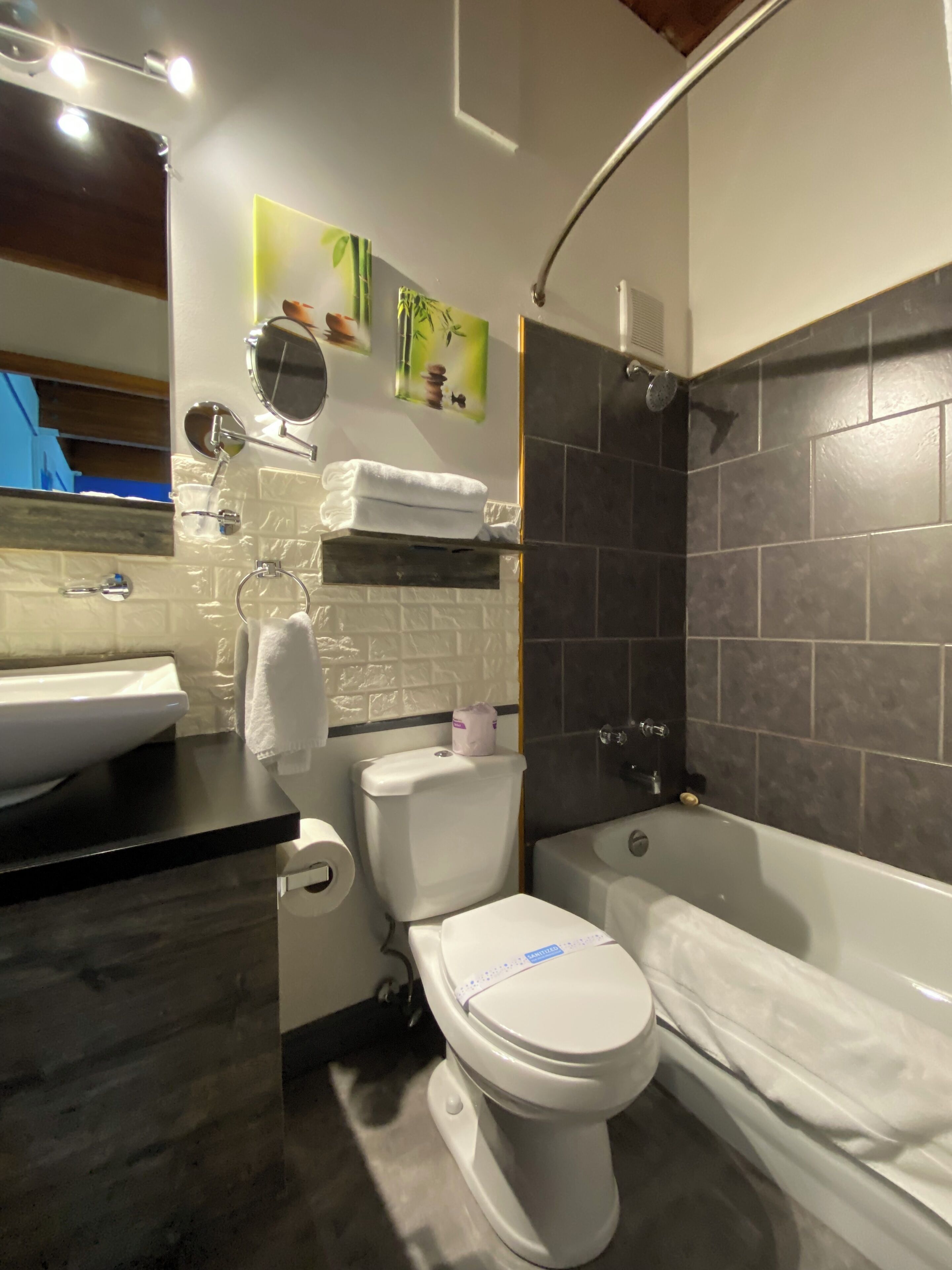 A modern bathroom with a toilet, sink, and bathtub.