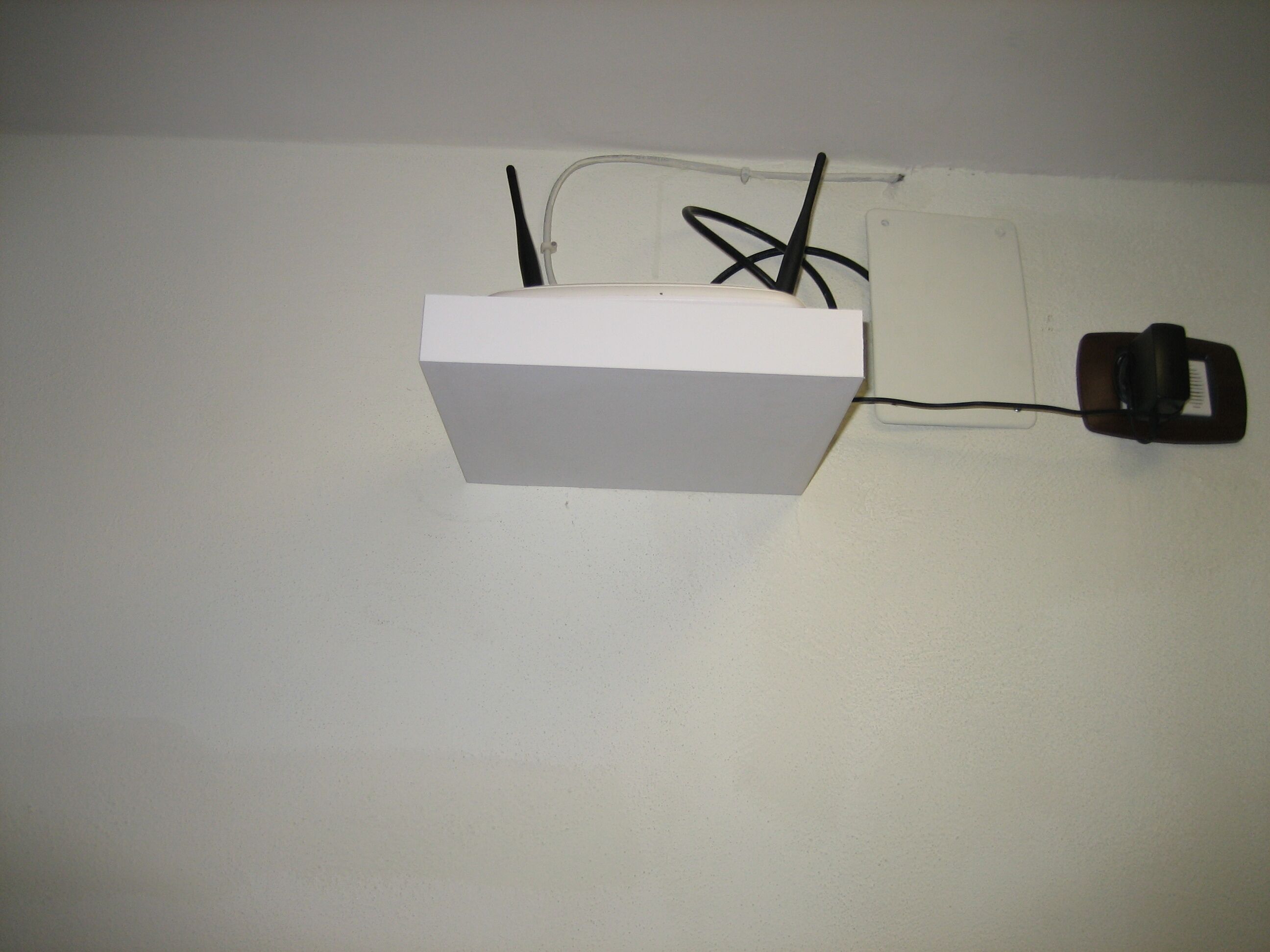 A white box with a black cable plugged into a wall socket.