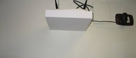 A white box with a black cable plugged into a wall socket.