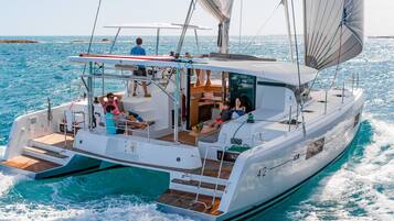 Un velero con cubierta amplia, zona de estar y vista al mar.