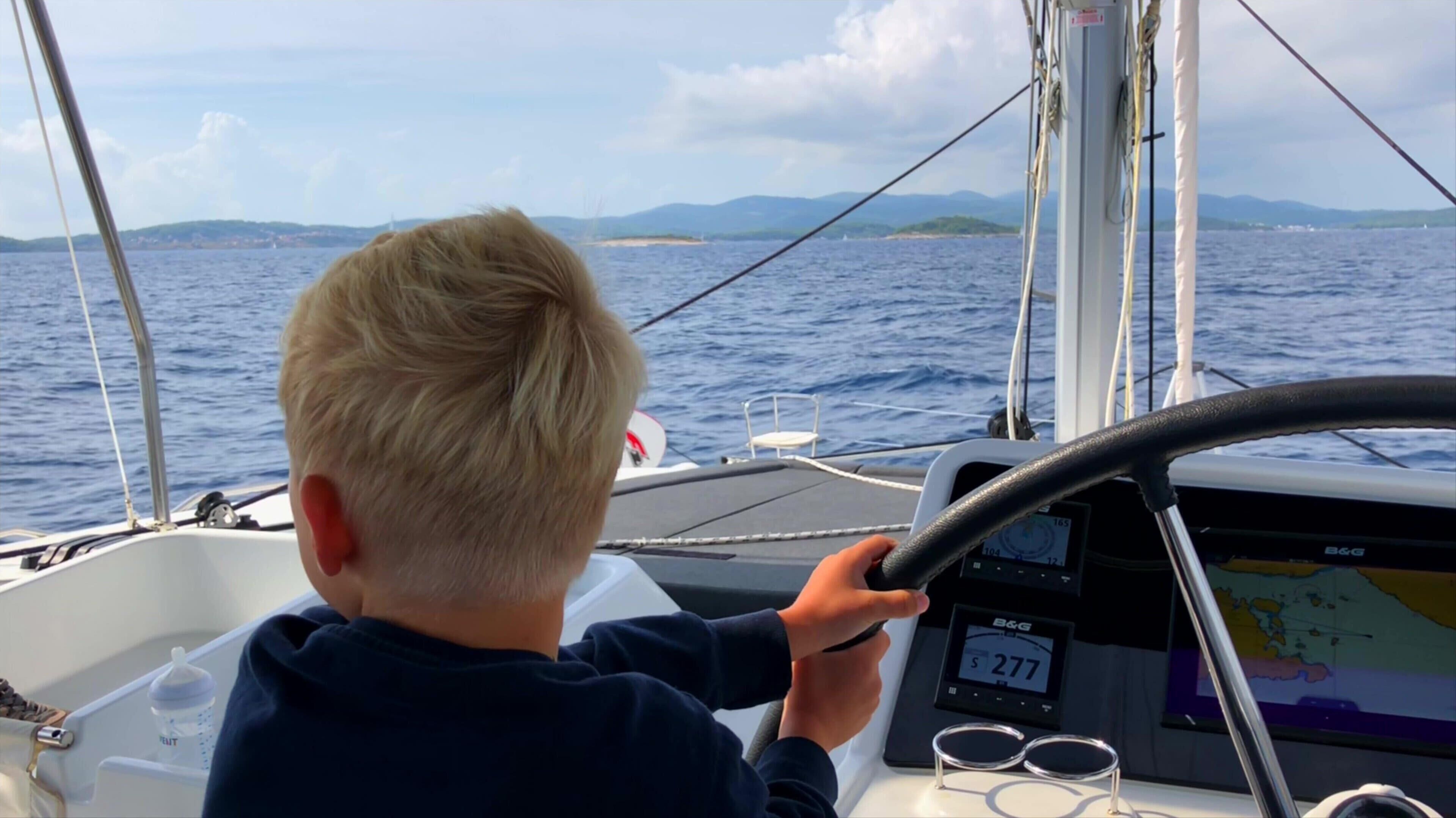 Uma pessoa manobrando um barco com um visor de navegação digital.