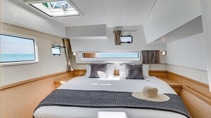 Un dormitorio moderno y luminoso con una cama grande, tragaluz y vistas al mar.
