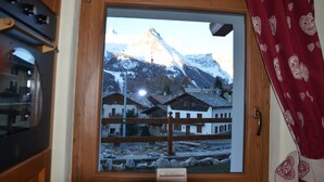 Una ventana con vista a una montaña y edificios.