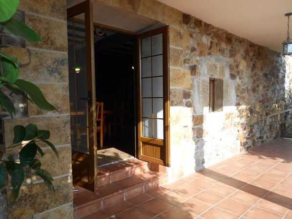 Traditional stone building with a wooden door and glass panels.