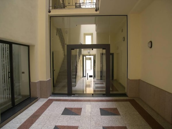 A hallway with a glass door leading to a staircase.