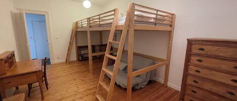 A room with a bunk bed, a dresser, a desk, and a chair.