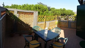 A patio with a table and chairs, surrounded by brick walls and potted plants. - Fantastic Penthouse in the center of Rome not far from the Vatican (Roma)