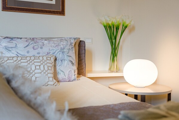 A neatly arranged hotel room with a bed, a bedside table with a lamp, and a vase with flowers. - 2 Bedrooms Apartment with Terrace and Elevator (Lucca)