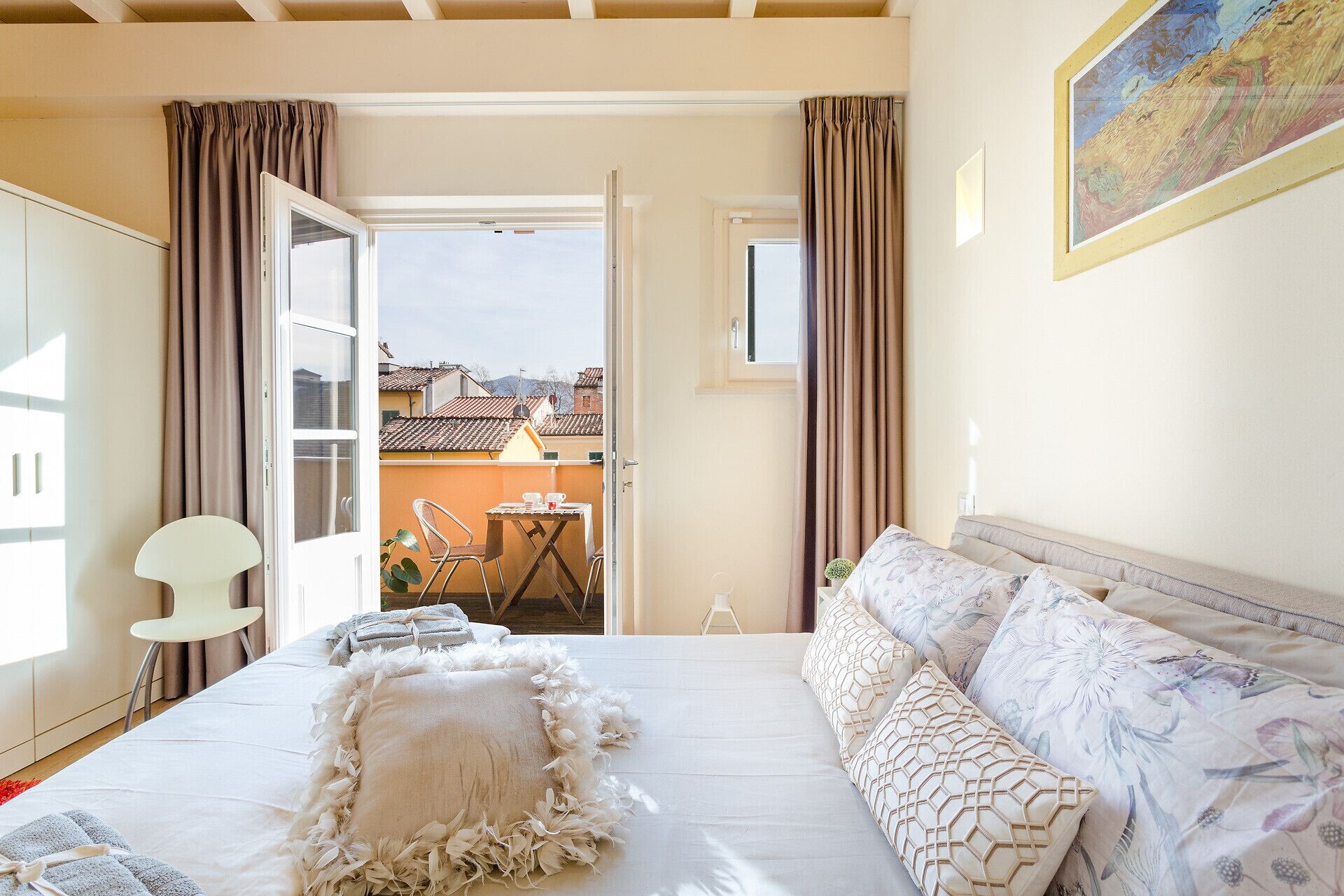 Un dormitorio con cama, una silla, una mesa y vistas al exterior.