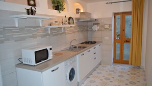 Cocina compacta con microondas, lavaplatos y lavadora.