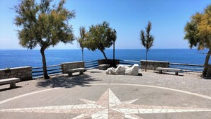 A coastal promenade with stone benches, a compass mosaic, and trees overlooking the sea. - Charming and cozy little house in the center of Pomonte, just steps from the sea (Pomonte)