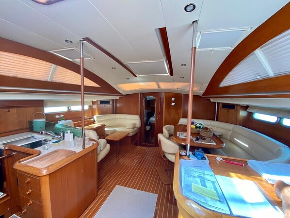 A yacht interior with a dining area, a kitchen, and a lounge.