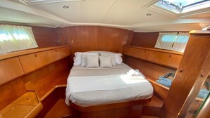 A compact cabin with a bed, a small seating area, and a wardrobe. - DREAM CRUISES SANTORINI,CYCLADES,MYKONOS, ON LUXURY SAILBOAT WITH HOSTESS/CHEF (Athina)