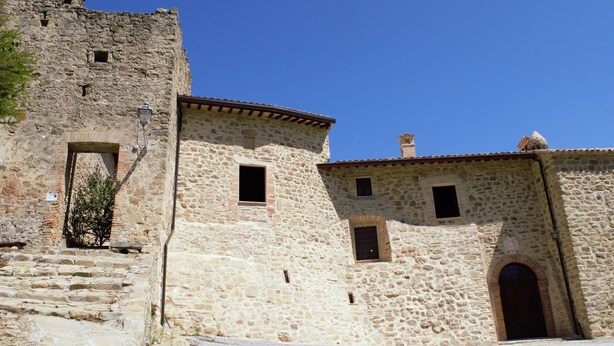 A stone building with a rustic appearance, featuring a small door and a window. - XIII century Castle overlooking an uncontaminated valley. (Gualdo Cattaneo)