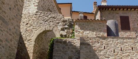 A stone building with a narrow passageway and a large stone archway.