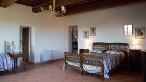 A bedroom with a wooden bed, two bedside tables, a chandelier, and a radiator. - XIII century Castle overlooking an uncontaminated valley. (Gualdo Cattaneo)