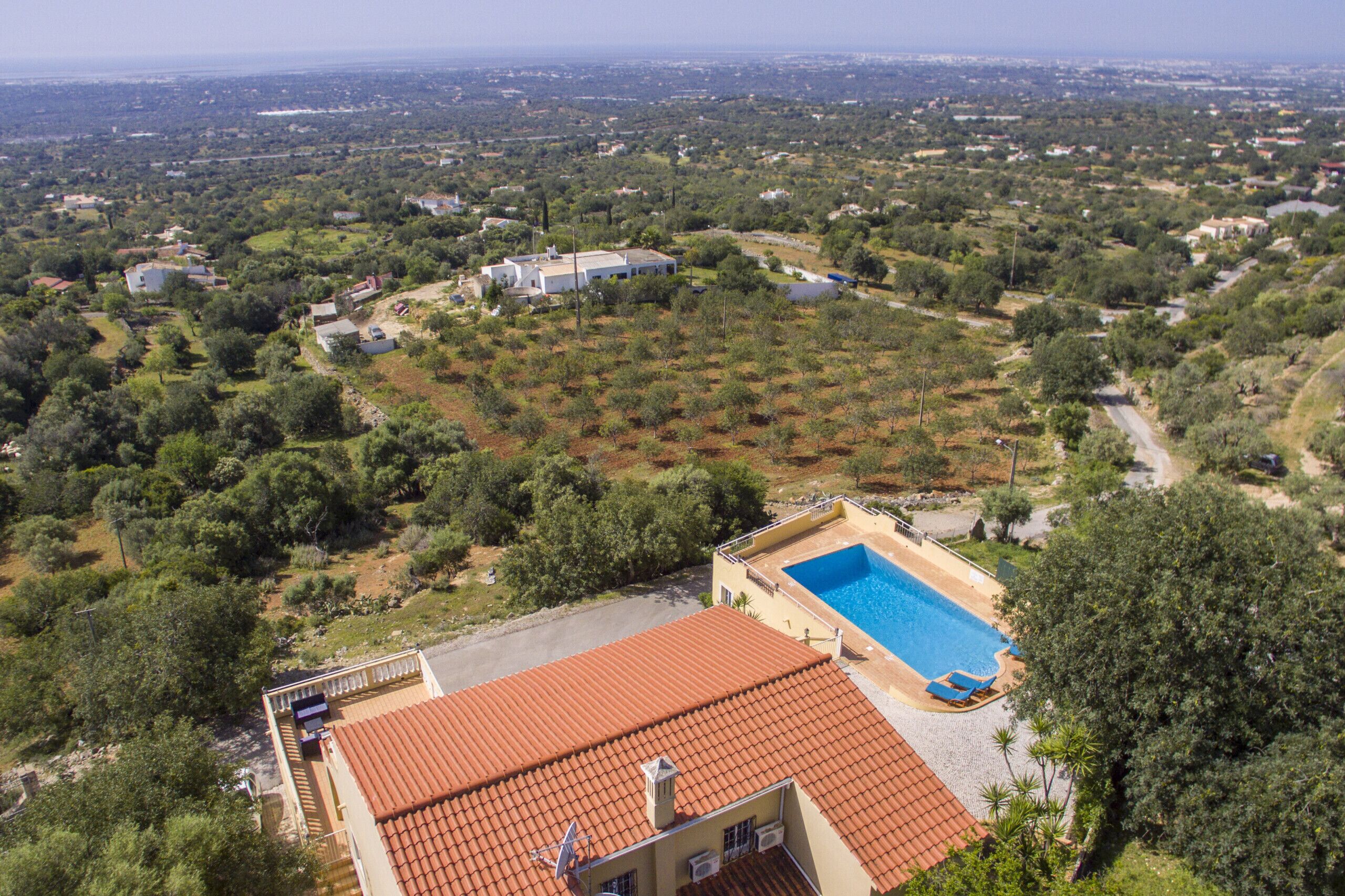 A residential area with a swimming pool, terraced houses, and a large house with a garden.