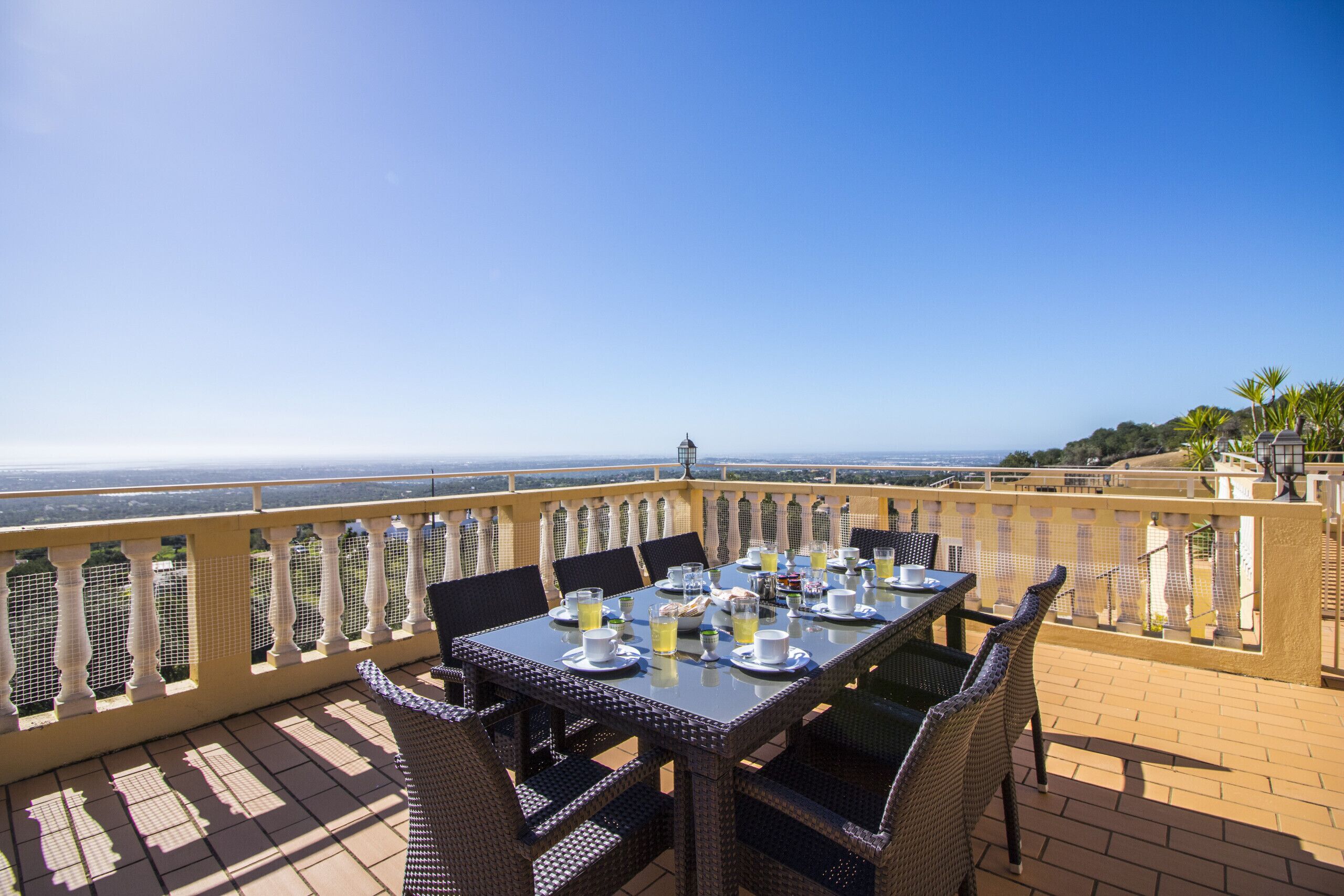 Eine Terrasse mit Esstisch und Blick auf eine schöne Aussicht.