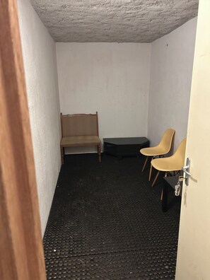 A small room with a bed, two chairs, and a door with a key in the lock. - Central Morzine Location, on a quiet road (Morzine)