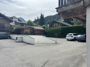 Un espace de stationnement avec un bâtiment en bois et une structure blanche.