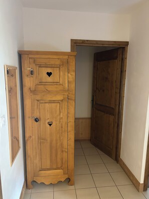 Une armoire en bois ornée d’une découpe en forme de cœur et dotée d’un cadenas.