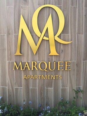 Logotipo de Marquee Apartments sobre un fondo de madera.