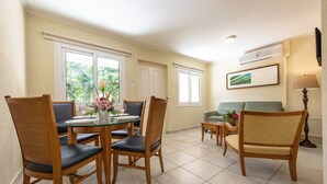 Un coin repas avec une table ronde et des chaises, un canapé et une lampe.