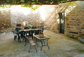 An outdoor patio with stone walls, a table with chairs, and a bench. - Holiday home in Galicia, 'Camino de Santiago, Via de la Plata' (Silleda-Pontevedra)