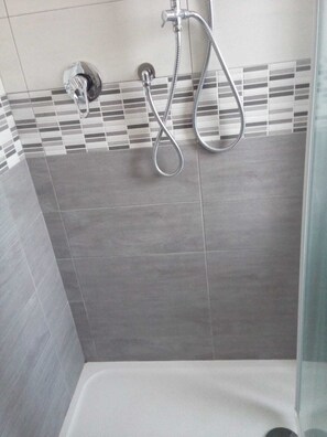 Chuveiro, secador de cabelo, bidê, toalhas de banho