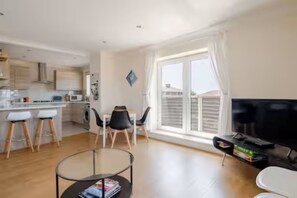 A modern apartment with a kitchen, dining area, and living space.