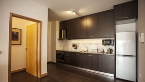 Una cucina moderna con mobili scuri, un frigorifero in acciaio inossidabile e un forno a microonde.