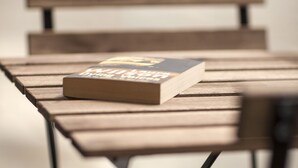 Una panchina di legno con un libro sopra.