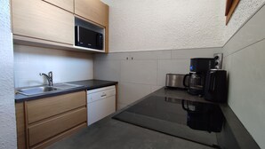 A compact kitchen with a microwave, coffee maker, toaster, and dishwasher.