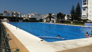 A swimming pool with clear blue water, surrounded by a white deck. - Luxury 3 bed apartment, on sea front, sleeps 6 (Torrox-Costa (Malaga))
