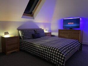 Ein Schlafzimmer mit einem Bett, einem Fernseher und einem Nachttisch.