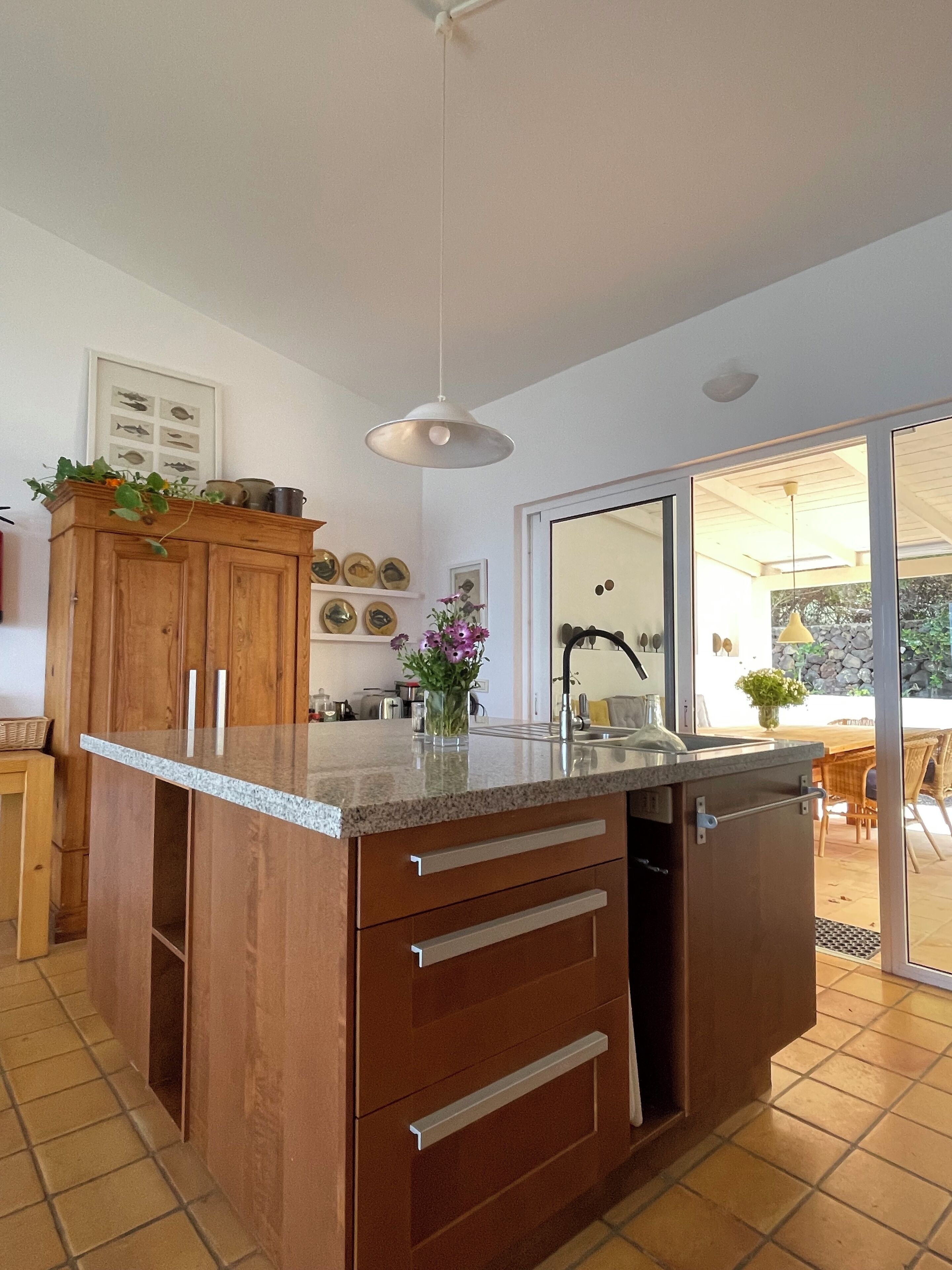 Una cocina moderna con encimera de granito, armarios de madera y lavavajillas integrado.