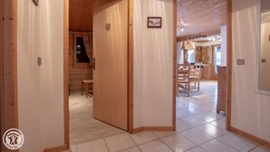 Ein geräumiges Zimmer mit einer Holztür, die in einen Küchenbereich führt.