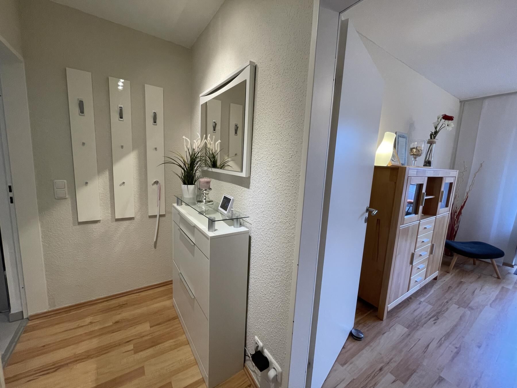Une salle de bain moderne avec un meuble-lavabo en verre, un grand miroir et une plante en pot.