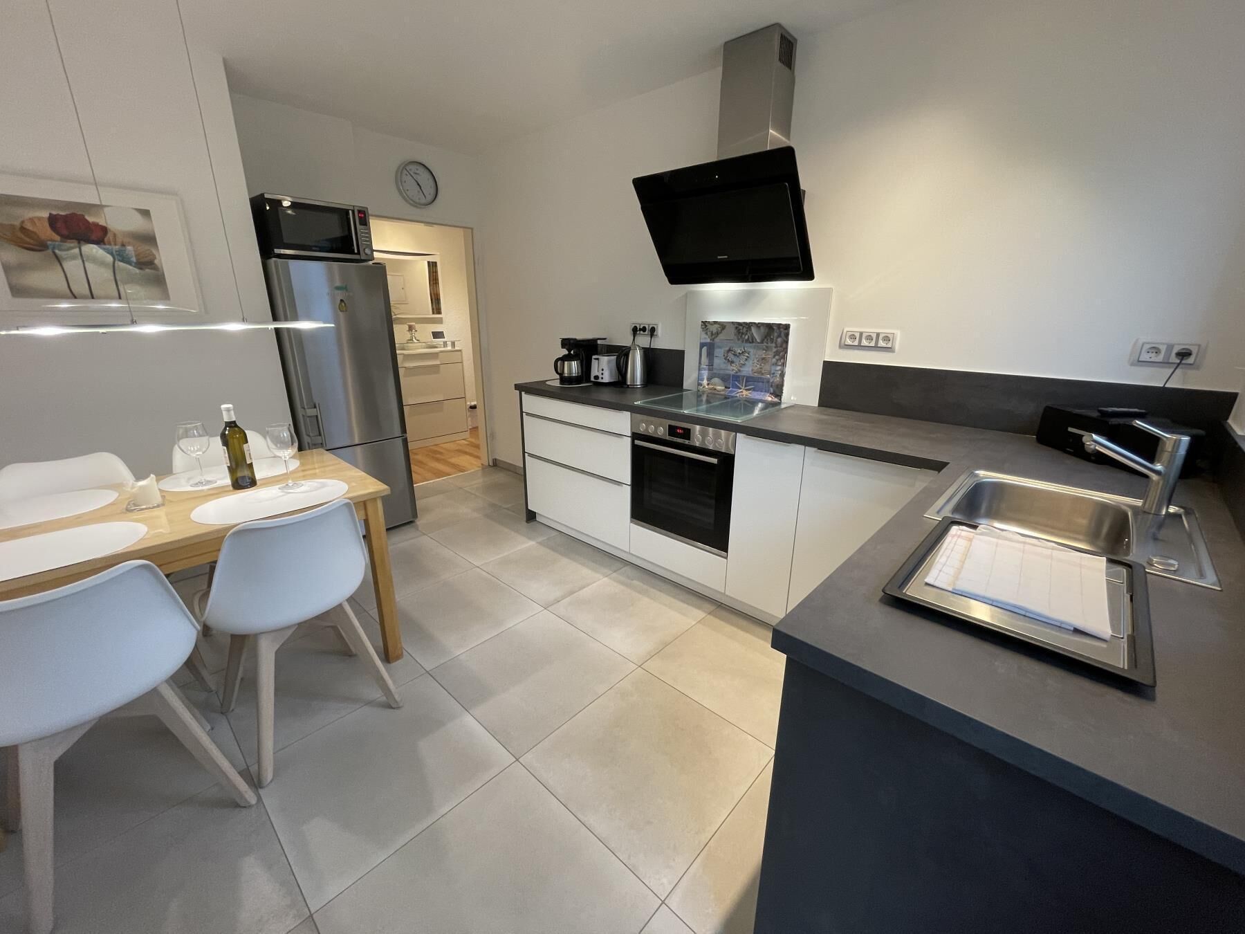 Una cocina moderna con comedor, electrodomésticos de acero inoxidable y un televisor de pantalla plana.